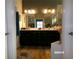 Bathroom showcasing a double vanity with dark cabinets, a large mirror, and modern fixtures at 10173 Julia Isles Ave, Oxford, FL 34484