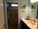 Bright bathroom with a single sink vanity and shower with fish themed curtain at 10173 Julia Isles Ave, Oxford, FL 34484