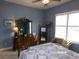 Comfortable bedroom featuring a traditional wood dresser and sitting area with natural light at 10173 Julia Isles Ave, Oxford, FL 34484