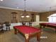 View of the billiards room with 2 pool tables, wallpaper and unique light fixtures at 10173 Julia Isles Ave, Oxford, FL 34484
