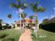 View of the clubhouse with lush lawn and palm trees on a sunny day at 10173 Julia Isles Ave, Oxford, FL 34484