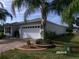 A well-maintained house featuring a two-car garage, manicured landscaping, and brick driveway at 10173 Julia Isles Ave, Oxford, FL 34484