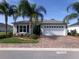 Charming single-story home boasts lush landscaping, a brick driveway, and an attached two car garage at 10173 Julia Isles Ave, Oxford, FL 34484