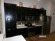 Spacious kitchen featuring stainless steel appliances, black cabinets, and white countertops at 10173 Julia Isles Ave, Oxford, FL 34484
