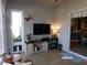 Cozy living room with decorative butterfly, television, sliding barn doors and tile floors at 10173 Julia Isles Ave, Oxford, FL 34484