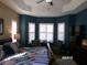 A spacious main bedroom featuring a tray ceiling, sitting area, and ample natural light from the many windows at 10173 Julia Isles Ave, Oxford, FL 34484