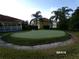 View of the community putting green surrounded by trees and landscaping at 10173 Julia Isles Ave, Oxford, FL 34484