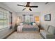 Bedroom with a ceiling fan, large windows, colorful bedding, and a small couch at 1041 Juliette Blvd, Mount Dora, FL 32757