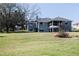Expansive backyard with a screened porch and deck provides outdoor living and entertaining space at 10648 Lake Hill Dr, Clermont, FL 34711