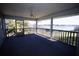 Covered balcony overlooking the lake with a ceiling fan and railing at 10648 Lake Hill Dr, Clermont, FL 34711