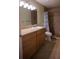Bathroom featuring a wooden vanity with granite countertops and a tiled shower with curtain at 10648 Lake Hill Dr, Clermont, FL 34711