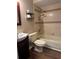 Bathroom with tiled shower-tub combination, toilet, and sink with dark wood vanity at 10648 Lake Hill Dr, Clermont, FL 34711