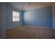 This bedroom has blue walls, carpeted floors, and one large window at 10648 Lake Hill Dr, Clermont, FL 34711