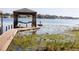 Lakeside dock with covered boat lift offers serene water views and direct lake access at 10648 Lake Hill Dr, Clermont, FL 34711