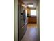 Galley kitchen featuring stainless steel refrigerator and sink with wooden cabinets at 10648 Lake Hill Dr, Clermont, FL 34711
