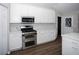 Well-lit kitchen featuring white cabinets, stainless steel appliances, and durable flooring at 10648 Lake Hill Dr, Clermont, FL 34711
