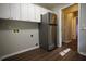 Laundry room with overhead cabinets and stainless steel refrigerator at 10648 Lake Hill Dr, Clermont, FL 34711