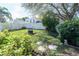 Backyard featuring lush landscaping, a fire pit area, and a privacy fence at 10910 Rushwood Way, Clermont, FL 34714