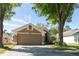 Inviting house boasts mature shade trees, a two-car garage, and a cozy front porch at 10910 Rushwood Way, Clermont, FL 34714
