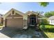 Inviting single-story home featuring a two-car garage, screened front entry, and well-kept landscaping at 10910 Rushwood Way, Clermont, FL 34714