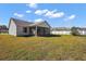 View of the home's backyard showing the lawn, fence and screened in patio at 12050 Ne 51St Cir, Oxford, FL 34484
