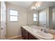 Bathroom with double sink vanity, large mirror, wood cabinets, and tile floors at 12050 Ne 51St Cir, Oxford, FL 34484