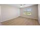 Bright bedroom featuring a ceiling fan, window with blinds, and wood-look flooring at 12050 Ne 51St Cir, Oxford, FL 34484