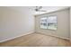 Bright bedroom featuring a ceiling fan, window with blinds, and wood-look flooring at 12050 Ne 51St Cir, Oxford, FL 34484