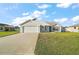 Charming single-story home with a well-manicured lawn and attached two-car garage at 12050 Ne 51St Cir, Oxford, FL 34484