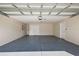 Spacious two car garage featuring epoxy flooring and overhead storage at 12050 Ne 51St Cir, Oxford, FL 34484