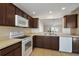 Well-lit kitchen with ample counter space, white appliances, and views into the living areas at 12050 Ne 51St Cir, Oxford, FL 34484