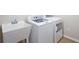 Laundry room with a sink, top load washer and dryer, and wood-look flooring at 12050 Ne 51St Cir, Oxford, FL 34484