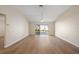 Spacious living room with wood floors, neutral walls, and access to the screened lanai through sliding glass doors at 12050 Ne 51St Cir, Oxford, FL 34484