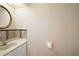 Cozy half bathroom featuring a round mirror and decorative tiled backsplash at 1223 Overlook Rd, Eustis, FL 32726