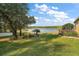 Expansive backyard leading to a peaceful lake, enhanced by lush landscaping and mature trees at 125 Twin Lake Cir, Umatilla, FL 32784