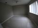 Neutral bedroom featuring tiled floor, a bright window, and a ceiling fan, awaiting your personal touch at 13742 Vista Del Lago Blvd, Clermont, FL 34711