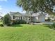 Inviting single-story home with green lawn, mature tree, and neutral siding, creating a serene curb appeal at 1414 Georgetown Ave, The Villages, FL 32162