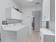 Bright laundry room features a washing machine, cabinets, and tile floors with access to other areas at 1414 Georgetown Ave, The Villages, FL 32162