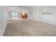 Spacious living room with neutral carpet and large windows, open to kitchen and dining, creating a welcoming space at 1414 Georgetown Ave, The Villages, FL 32162