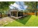 Wide angle view of backyard featuring lush green grass and an enclosed porch at 1511 Whooping Dr, Groveland, FL 34736