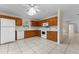 Bright kitchen featuring tile flooring, wood cabinets, white appliances, and a window, creating a clean and functional space at 1511 Whooping Dr, Groveland, FL 34736