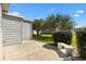 Backyard features a small patio area surrounded by mature landscaping, grass, and a stone bench at 1523 W Schwartz Blvd, Lady Lake, FL 32159