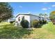 Exterior home view with manicured lawn, mature landscaping and plenty of parking spaces at 1523 W Schwartz Blvd, The Villages, FL 32159