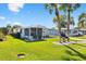 Exterior view of a well-maintained home with lush landscaping and a charming golf cart at 1523 W Schwartz Blvd, The Villages, FL 32159