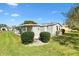 Manicured lawn and mature landscaping compliment the home's covered carport at 1523 W Schwartz Blvd, The Villages, FL 32159