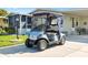 A silver Yamaha golf cart parked in front of a home with a screened-in porch at 1523 W Schwartz Blvd, The Villages, FL 32159