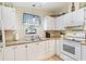 Well-lit kitchen with white cabinets, stainless steel sink, and modern appliances at 1523 W Schwartz Blvd, The Villages, FL 32159