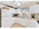Efficient kitchen with white cabinets, stainless steel sink, and compact appliances at 1523 W Schwartz Blvd, The Villages, FL 32159