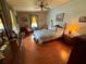 Spacious bedroom with wood-look flooring, neutral walls, ceiling fan, and cozy furniture at 1532 W Schwartz Blvd, Lady Lake, FL 32159