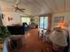 Comfortable living room with a ceiling fan, slider to lanai, and warm natural light at 1532 W Schwartz Blvd, Lady Lake, FL 32159